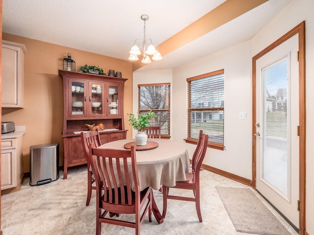 dining space featuring a notable chandelier and baseboards