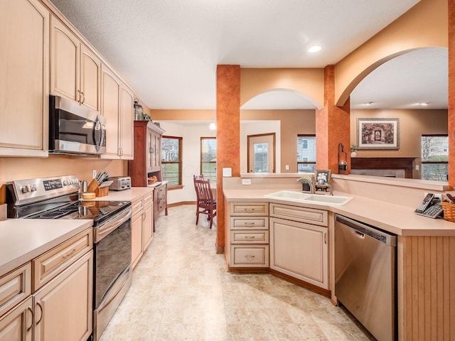 kitchen with appliances with stainless steel finishes, light countertops, and a sink