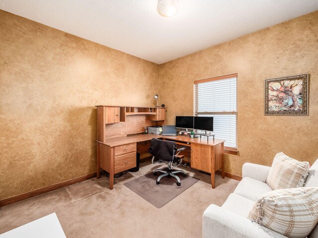 office space featuring light carpet and baseboards