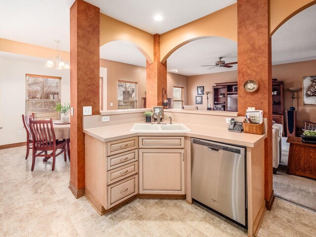 kitchen featuring dishwasher, light countertops, a sink, and a wealth of natural light