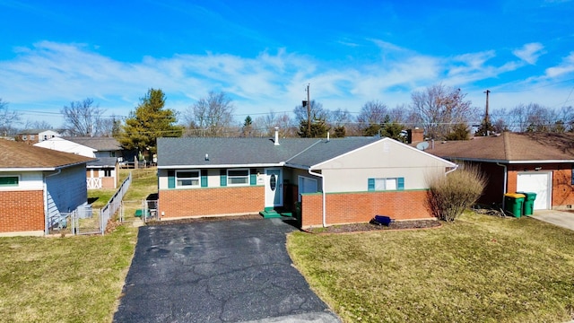 ranch-style home featuring aphalt driveway, a front lawn, fence, and brick siding