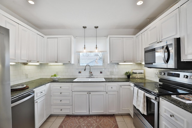 kitchen with stainless steel appliances, a sink, backsplash, and light tile patterned floors