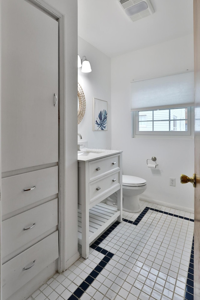 bathroom with toilet, tile patterned floors, visible vents, and vanity