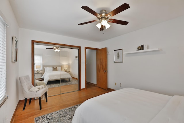 bedroom featuring a ceiling fan, baseboards, and wood finished floors