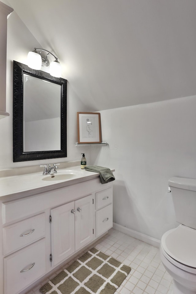 half bathroom with toilet, tile patterned floors, lofted ceiling, and vanity