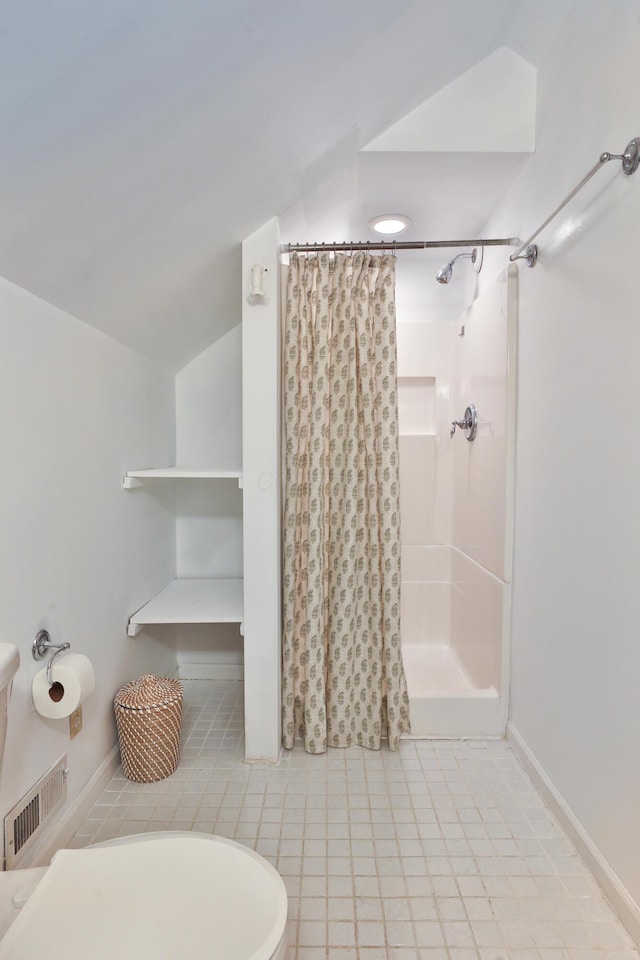 bathroom featuring toilet, visible vents, baseboards, vaulted ceiling, and a shower with curtain