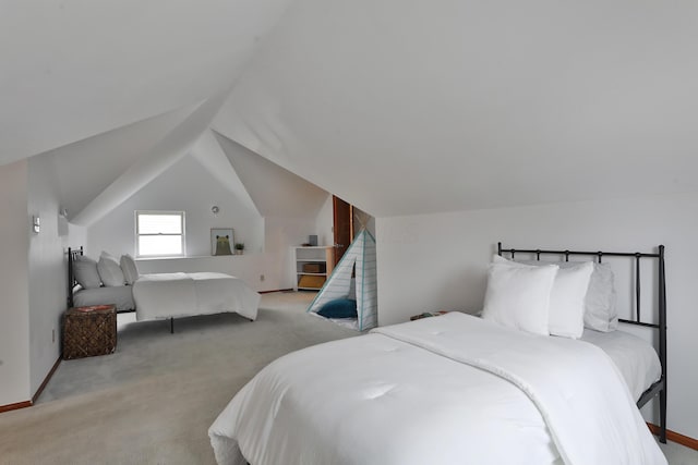 carpeted bedroom with lofted ceiling and baseboards