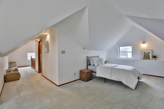 bedroom featuring light carpet, lofted ceiling, and baseboards