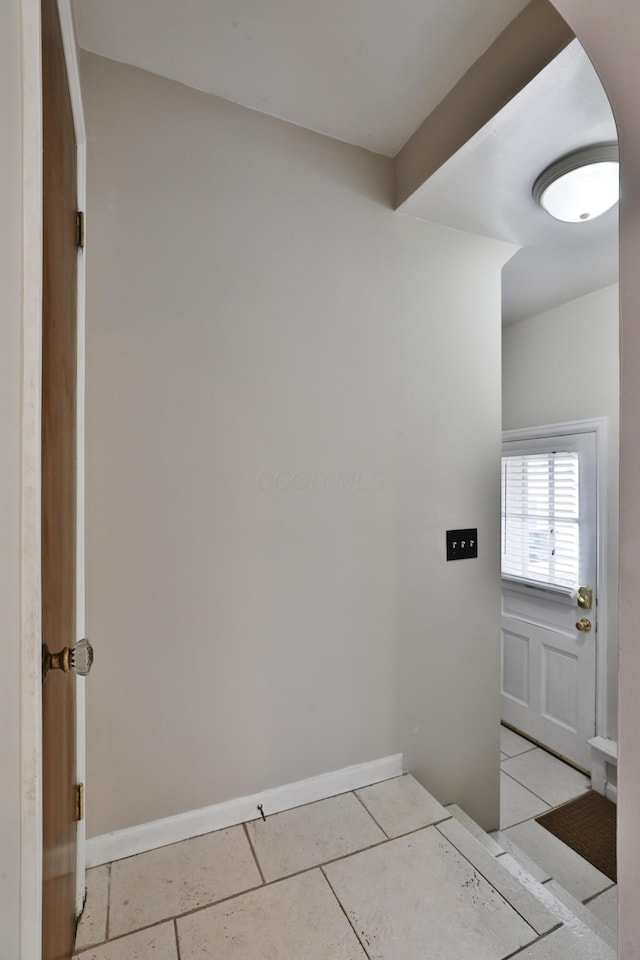 interior space featuring baseboards and arched walkways