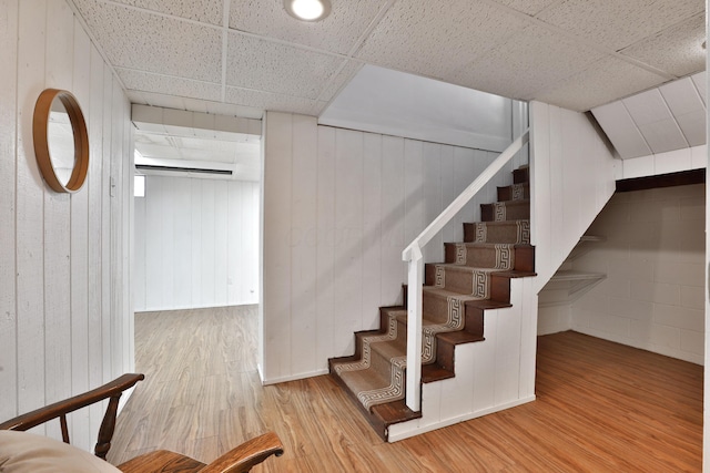 stairs featuring a drop ceiling and wood finished floors