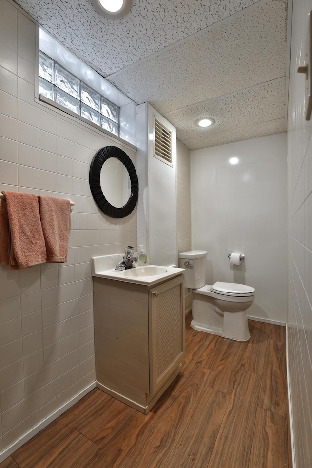 bathroom featuring toilet, visible vents, wood finished floors, and vanity