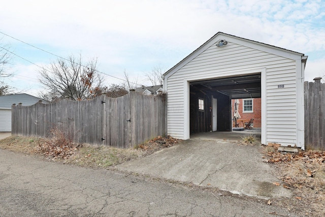 garage featuring driveway and fence