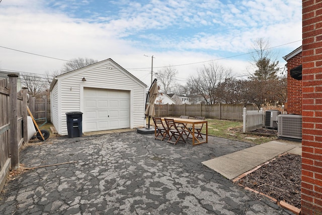 exterior space featuring central AC unit, fence, and aphalt driveway