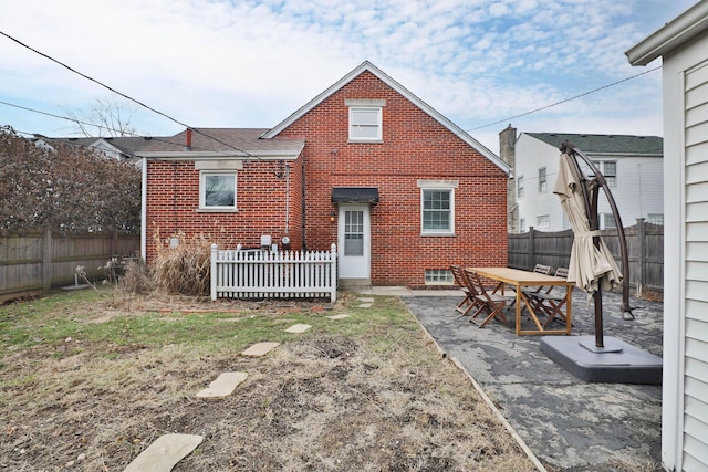 back of property featuring a patio area, brick siding, and a fenced backyard