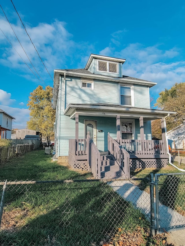 traditional style home with covered porch, a fenced front yard, a front yard, and a gate