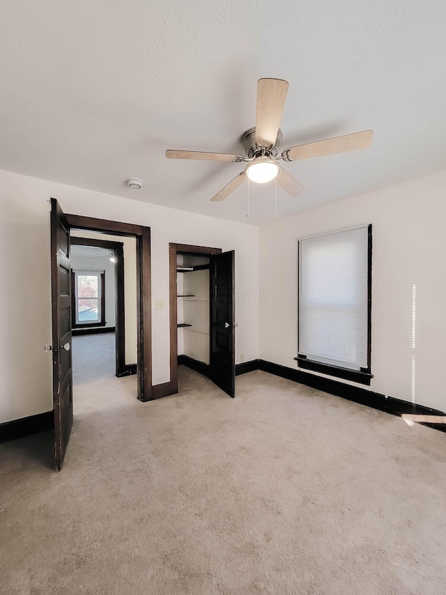 unfurnished bedroom featuring light carpet, ceiling fan, and baseboards