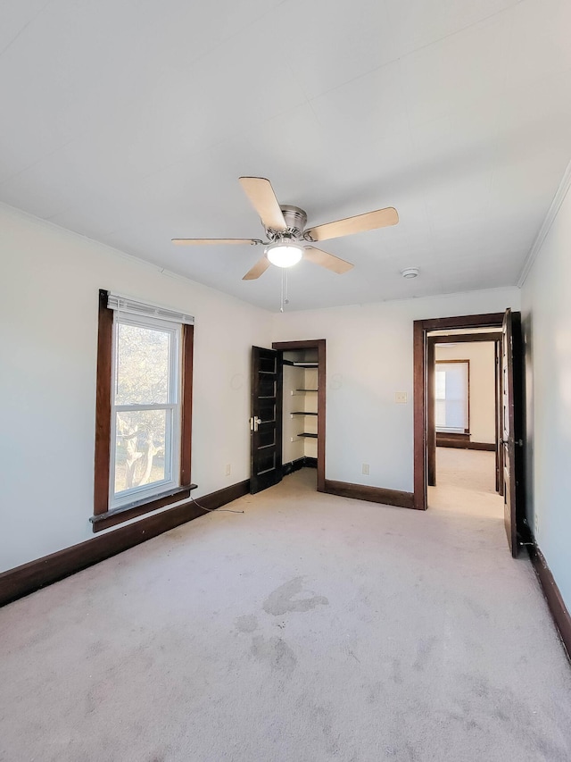 unfurnished bedroom with light colored carpet, ceiling fan, and baseboards