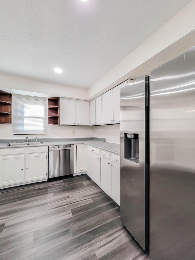 kitchen featuring stainless steel appliances, dark wood-style flooring, a sink, white cabinets, and open shelves