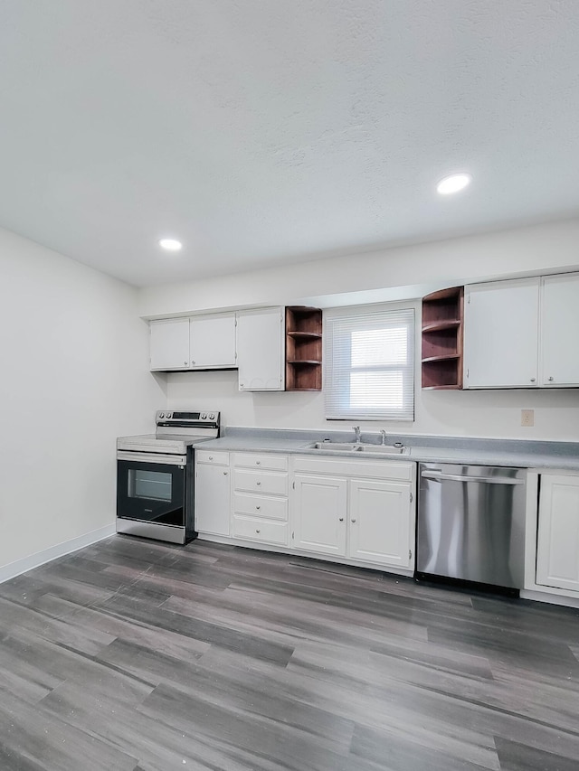 kitchen with wood finished floors, a sink, white cabinets, appliances with stainless steel finishes, and open shelves