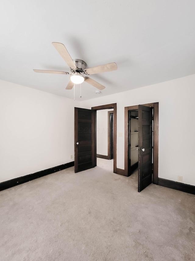 unfurnished bedroom featuring light carpet, baseboards, and a ceiling fan