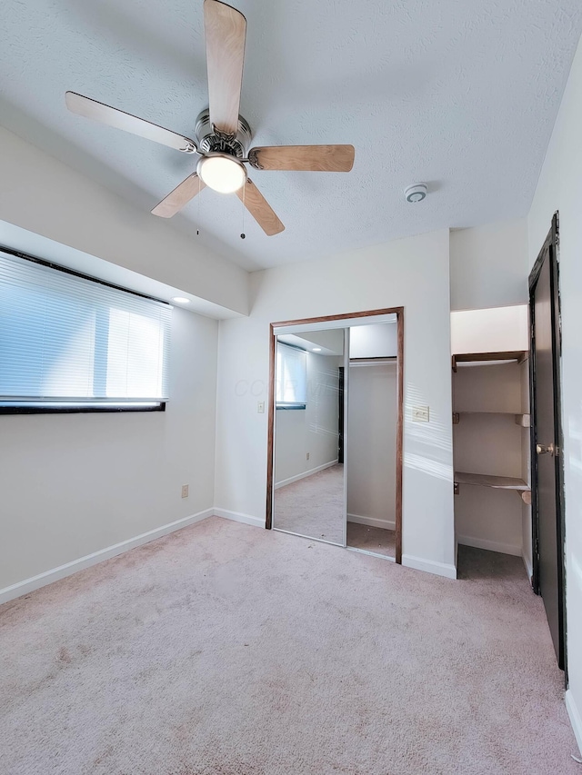 unfurnished bedroom featuring a textured ceiling, ceiling fan, carpet flooring, and baseboards