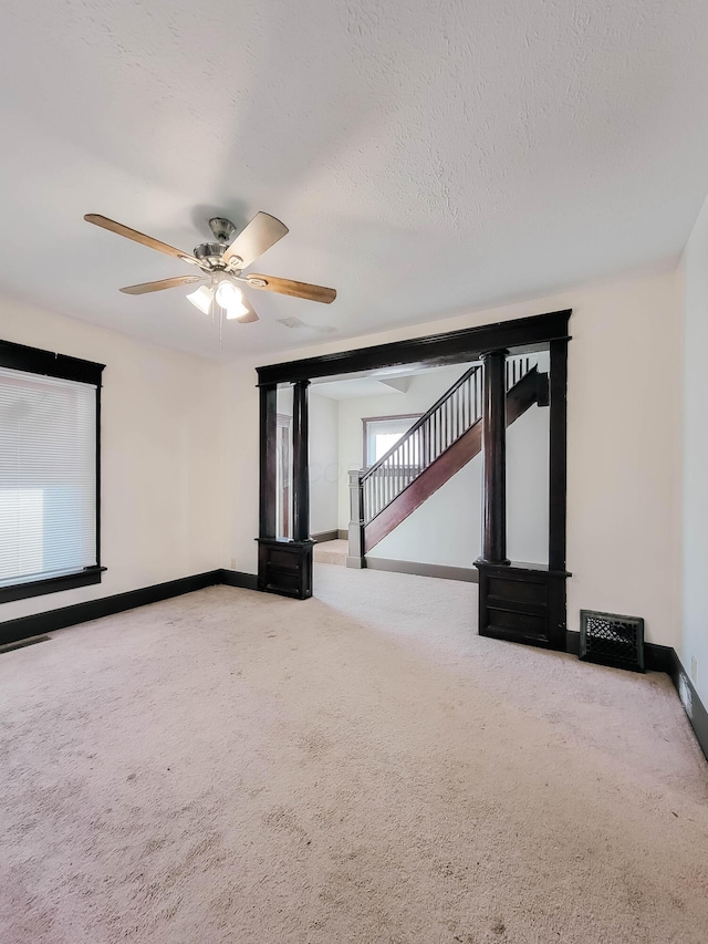 unfurnished room featuring stairs, a textured ceiling, carpet, and baseboards