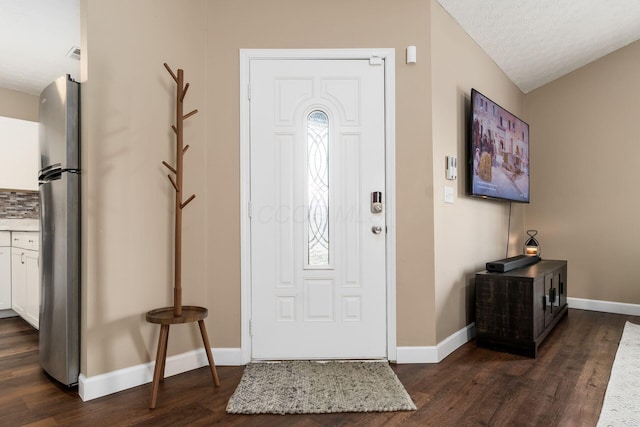 entrance foyer with a textured ceiling, baseboards, and dark wood-style flooring