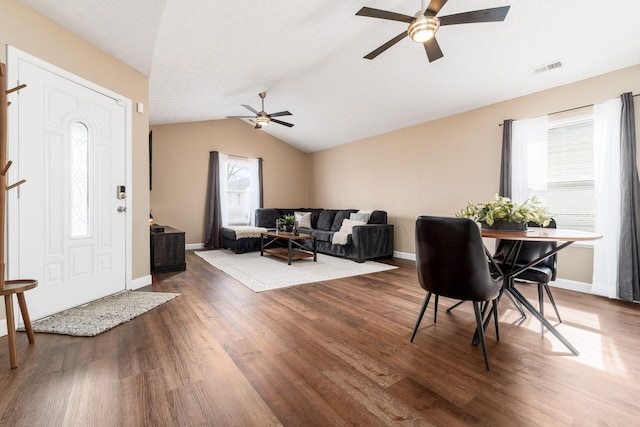 living room featuring baseboards, vaulted ceiling, and dark wood-style flooring