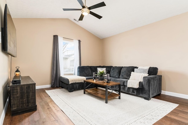 living room with lofted ceiling, visible vents, baseboards, and wood finished floors