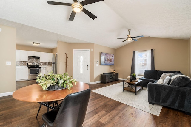 living area featuring dark wood-style floors, a ceiling fan, vaulted ceiling, a textured ceiling, and baseboards