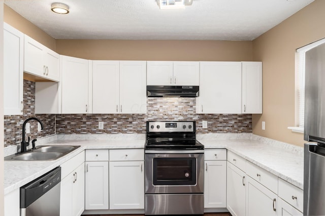 kitchen featuring stainless steel appliances, white cabinetry, a sink, and under cabinet range hood