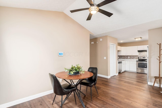 dining area with lofted ceiling, baseboards, dark wood finished floors, and a ceiling fan