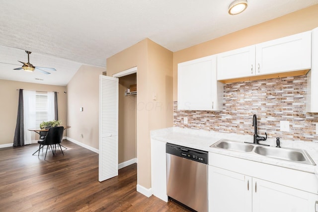 kitchen featuring dark wood finished floors, light countertops, stainless steel dishwasher, white cabinetry, and a sink