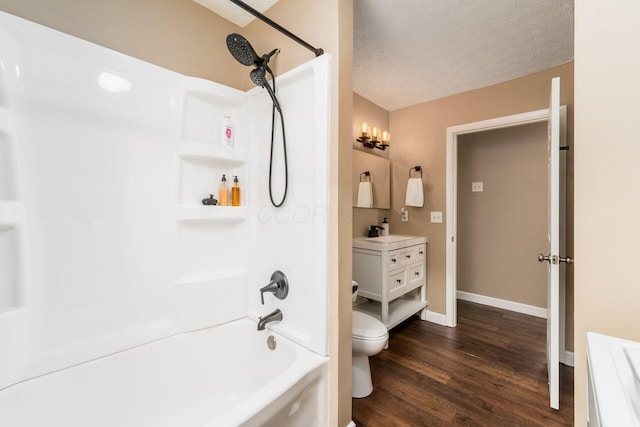 bathroom with a textured ceiling, toilet, wood finished floors, vanity, and baseboards