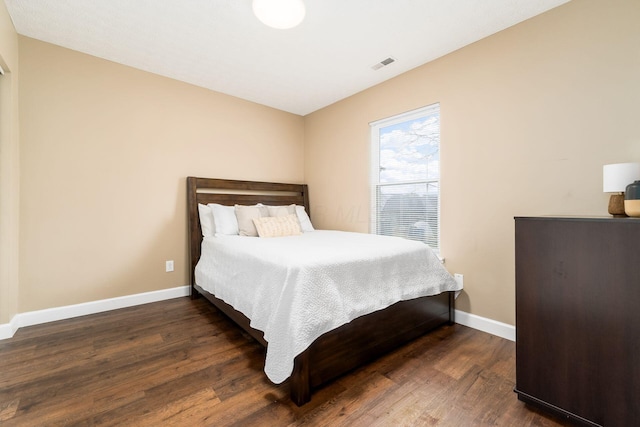 bedroom with wood finished floors, visible vents, and baseboards