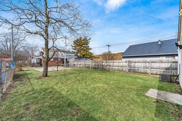 view of yard with fence and central AC