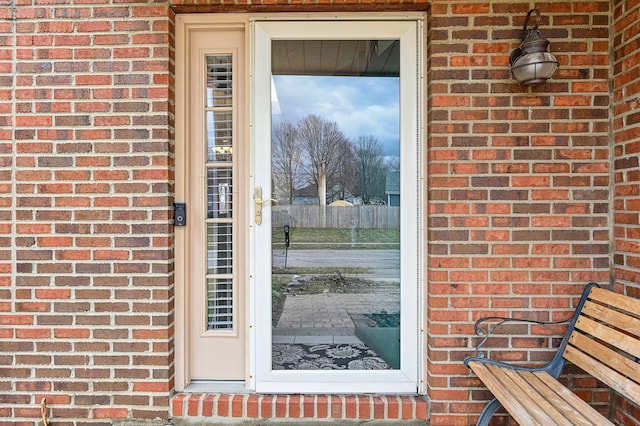 view of exterior entry with brick siding