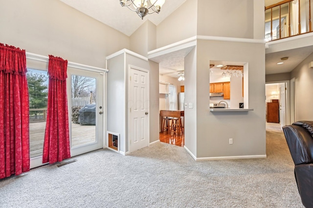 interior space with carpet floors, high vaulted ceiling, baseboards, and visible vents