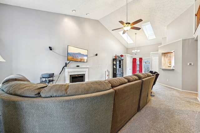 carpeted living room with a skylight, high vaulted ceiling, a tile fireplace, baseboards, and ceiling fan with notable chandelier