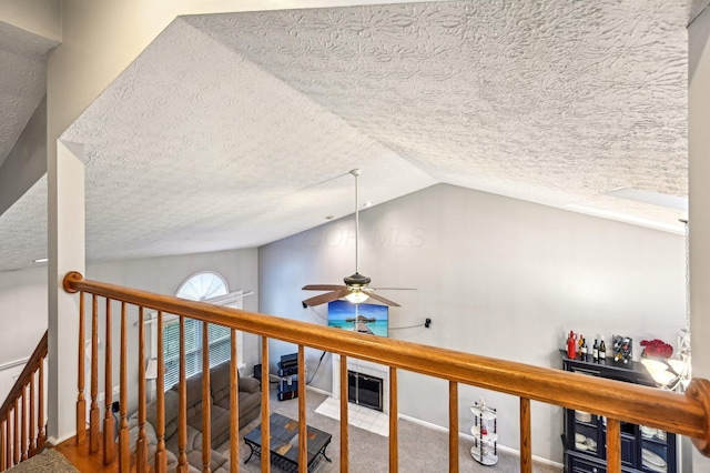 interior space featuring carpet, vaulted ceiling, and a textured ceiling