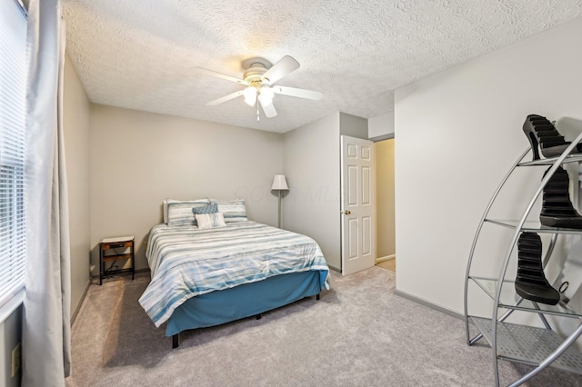 bedroom with ceiling fan, a textured ceiling, carpet flooring, and baseboards