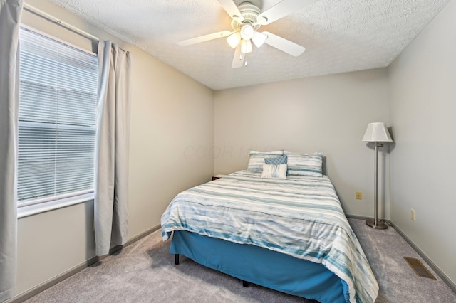 carpeted bedroom featuring visible vents, ceiling fan, a textured ceiling, and baseboards