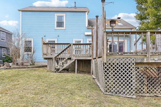 back of house featuring a yard, a deck, and stairs