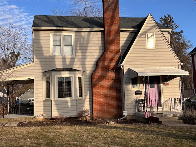 view of front of property with a chimney and a front lawn