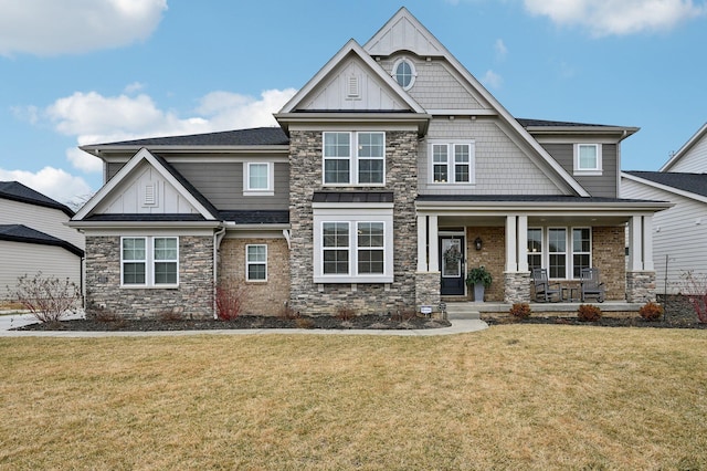 craftsman inspired home featuring board and batten siding, a porch, and a front lawn