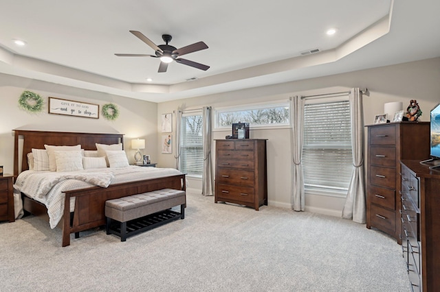 bedroom featuring a tray ceiling, recessed lighting, visible vents, and light colored carpet