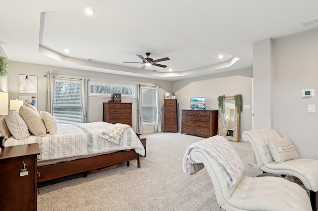 bedroom featuring light carpet, a tray ceiling, visible vents, and recessed lighting