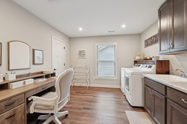 clothes washing area with dark wood-style flooring, visible vents, baseboards, cabinet space, and washer and clothes dryer