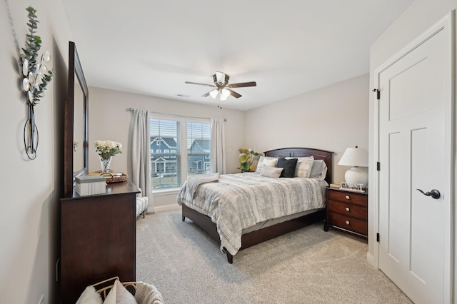 bedroom with a ceiling fan, light colored carpet, visible vents, and baseboards