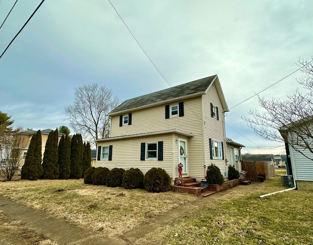 view of front of property featuring central AC, a front lawn, and fence